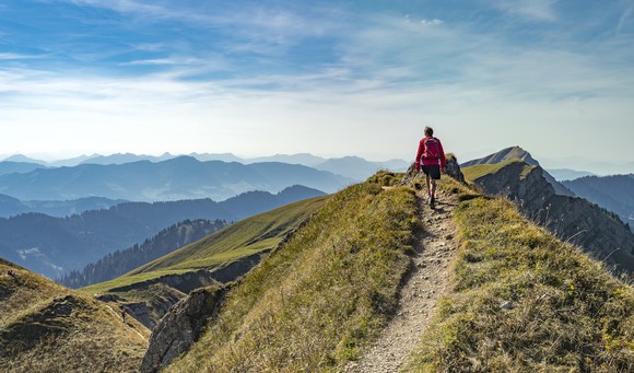 A lone hiker walking up a mountain trail