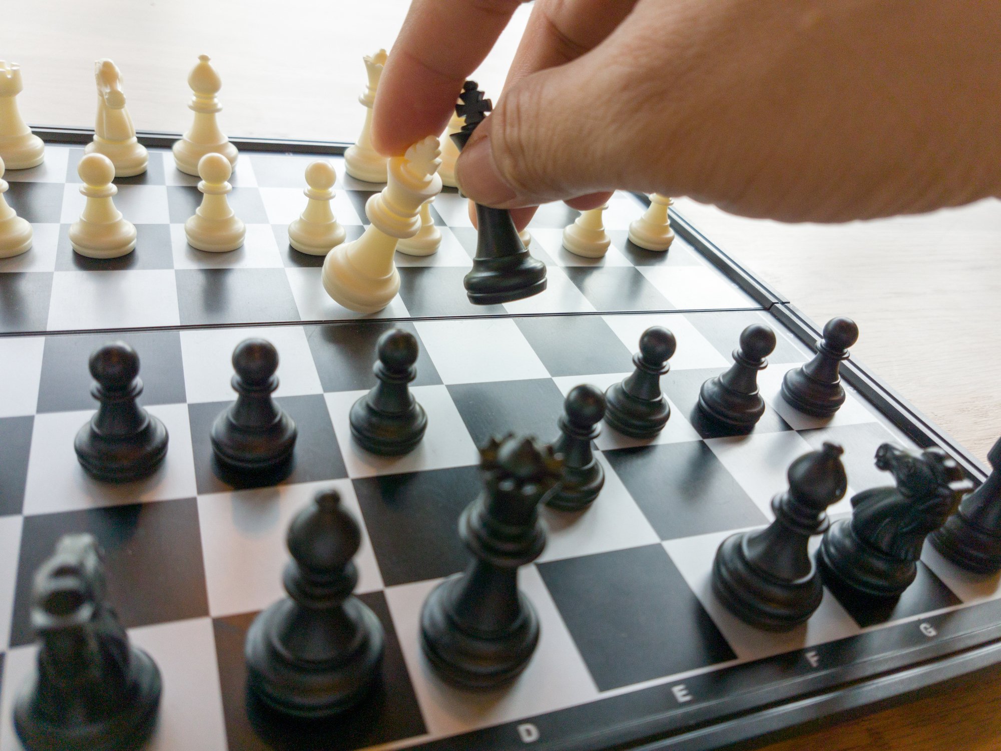Chess player capturing a piece on a chess board.