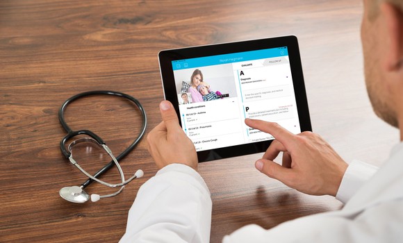 A physician consulting patients via tablet device.