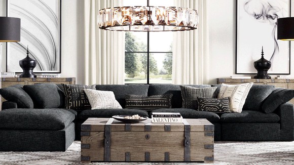 A living room arrangement from RH with sofa, coffee table, chandelier, and other decor.