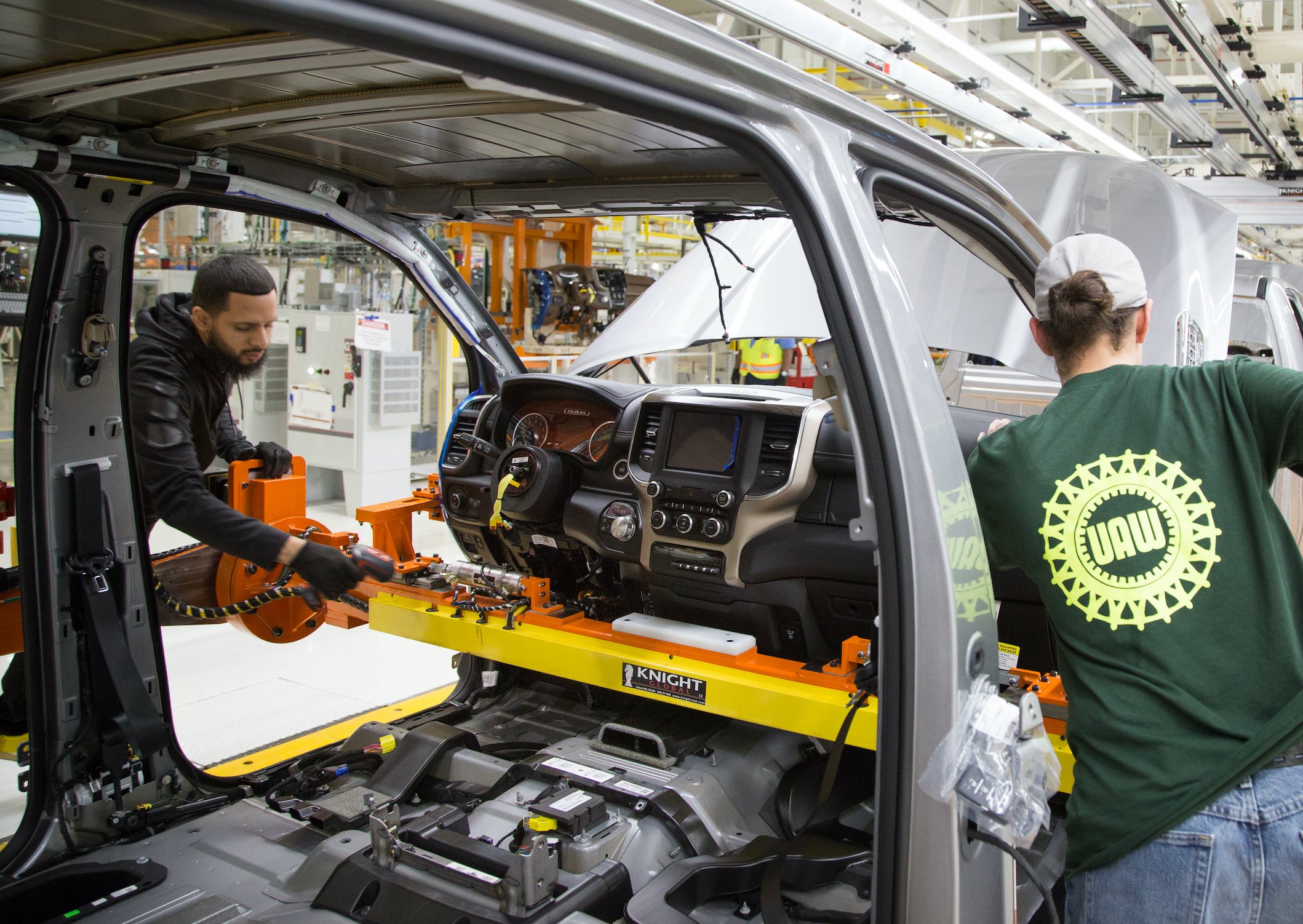 Workers at FCA's Sterling Heights Assembly Plant in Michigan install a dashboard in a Ram 1500 pickup truck. 