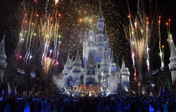 The Disney castle at night during a fireworks display.