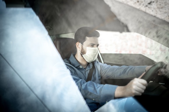 A ride hailing driver wearing a mask inside the vehicle. 