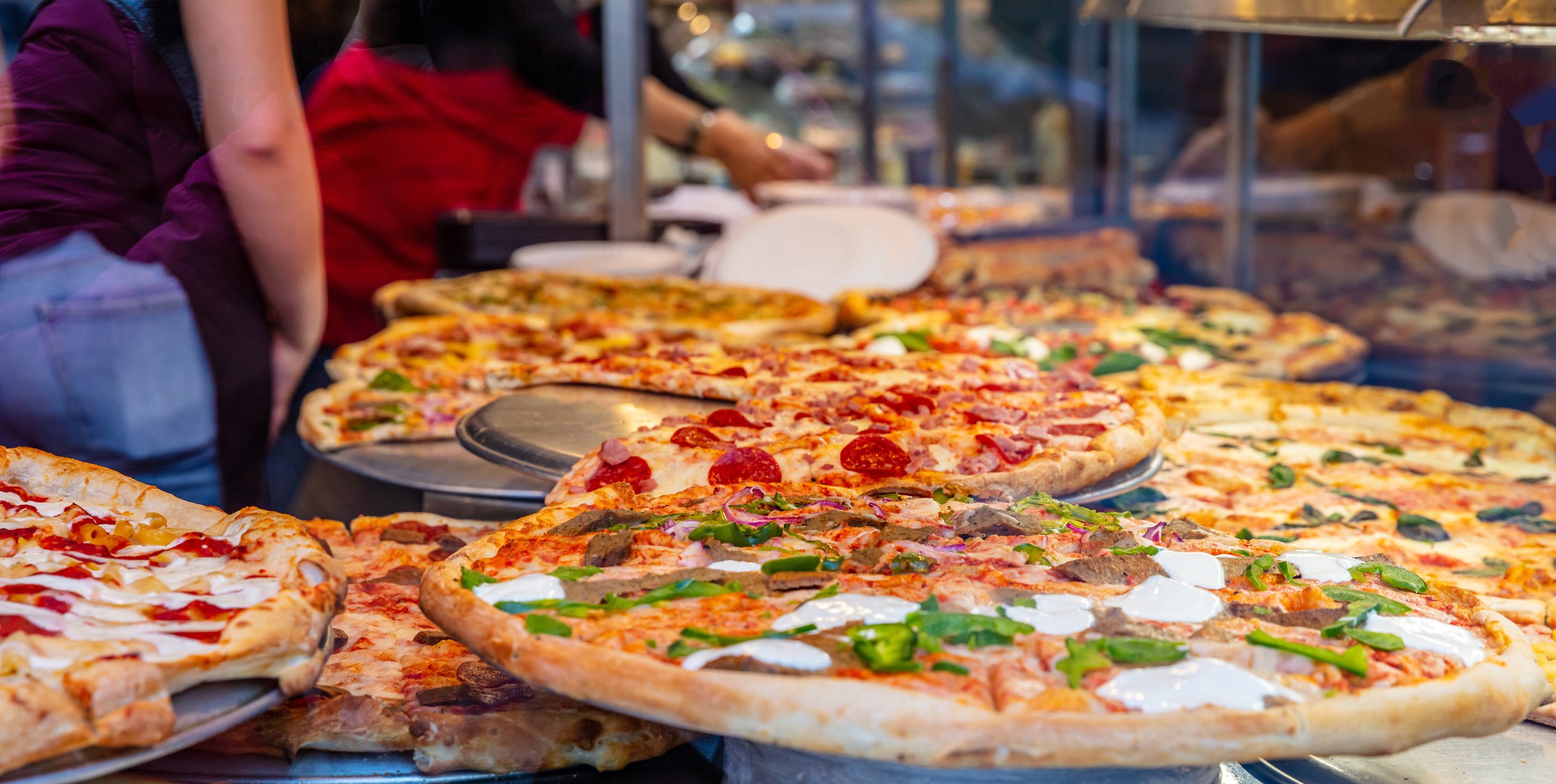 Pizzas inside a display case.