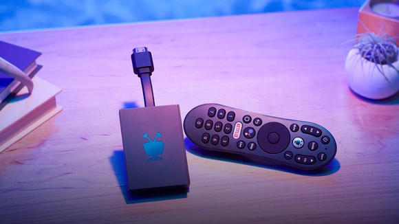 The TiVo Stream 4K media dongle and its remote control resting on a living room table