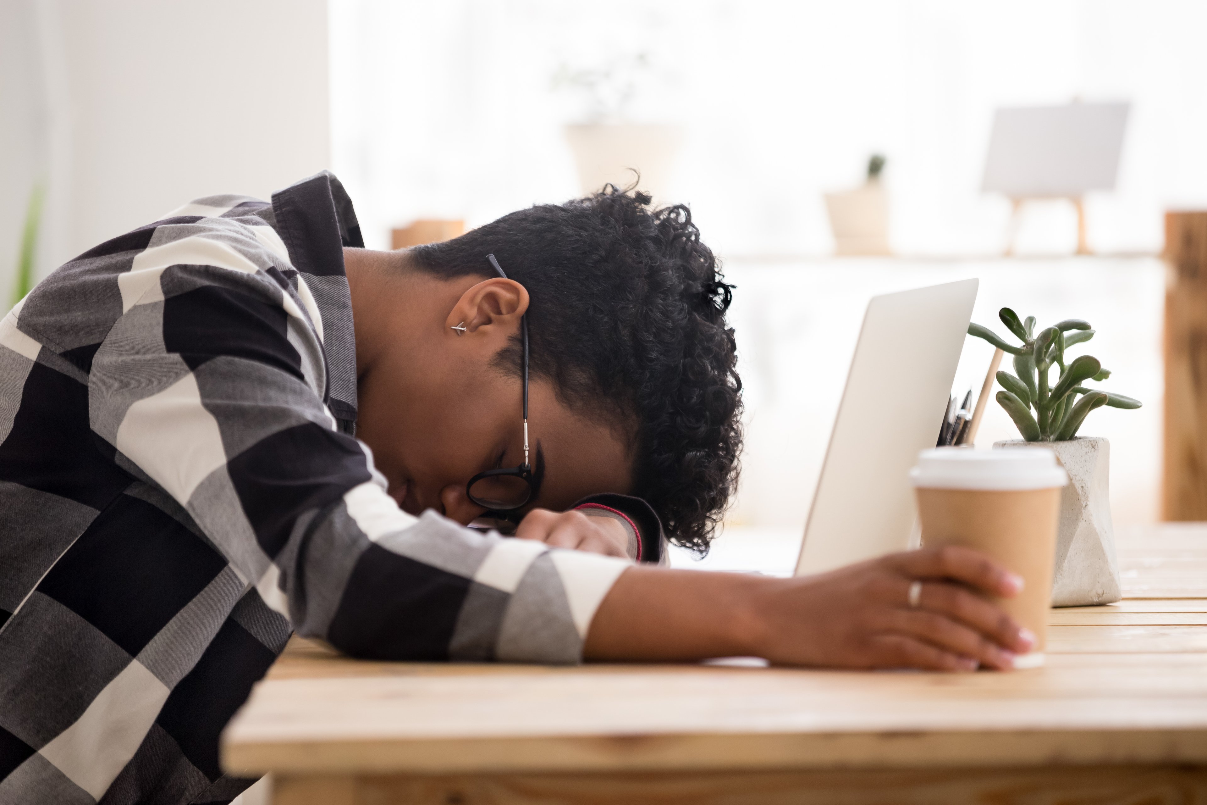 African woman falls asleep by the coffee desk during the day.