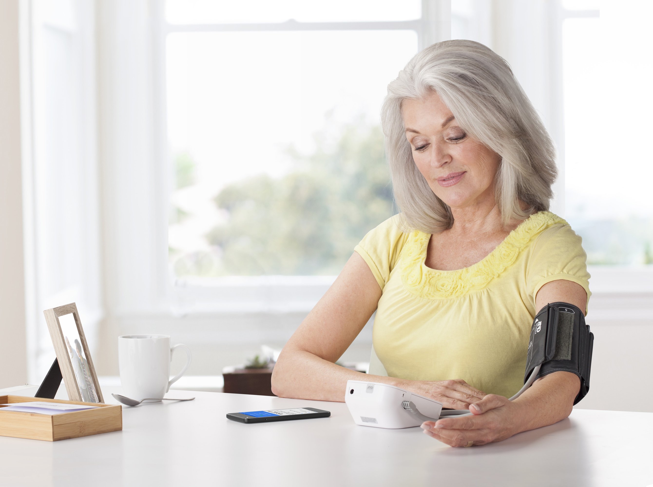 A woman uses a Livongo monitor while sitting at her desk at home.