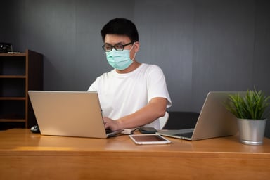 Man with mask working from home