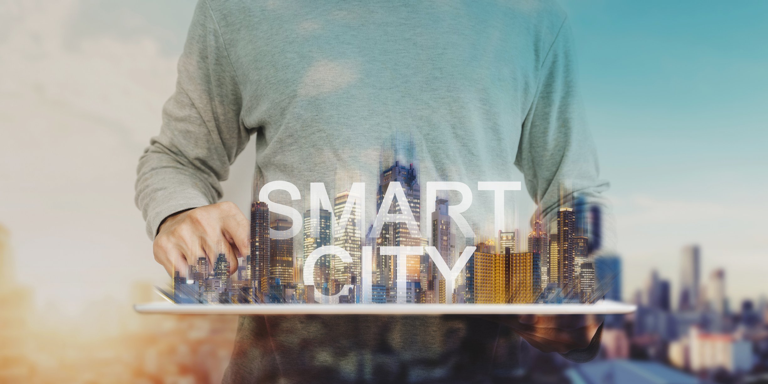 Man holding model of city displaying the words "Smart City."