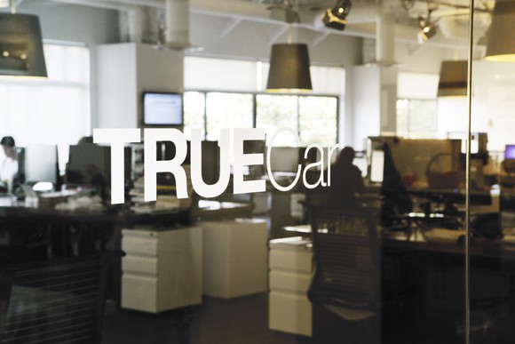 A glass door with TrueCar's logo at the entrance to its offices.