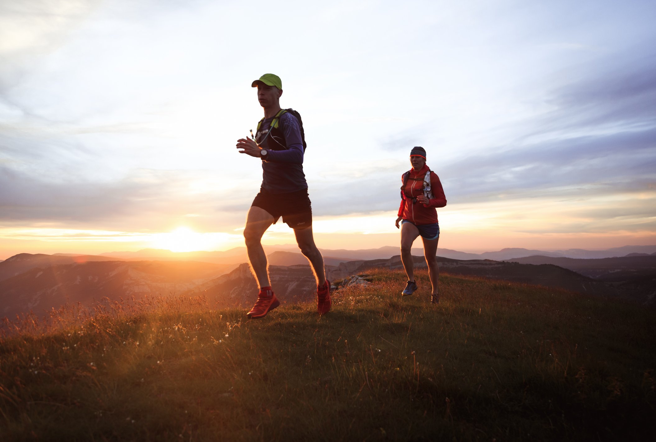 trail runners on a mountain at sunrise