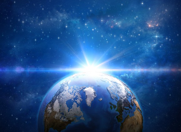 earth from space with sun emerging behind earth