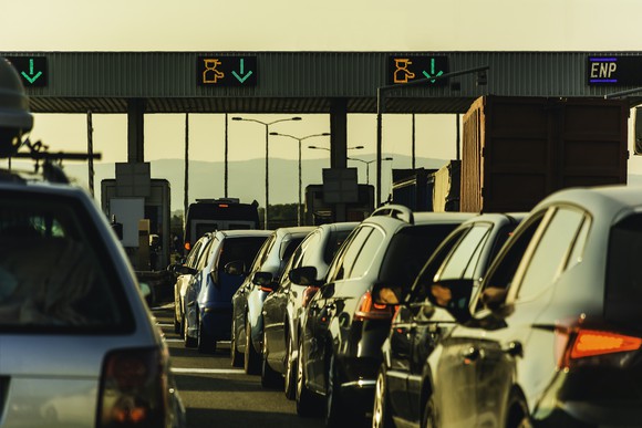 Lines of cars at a highway toll booth.