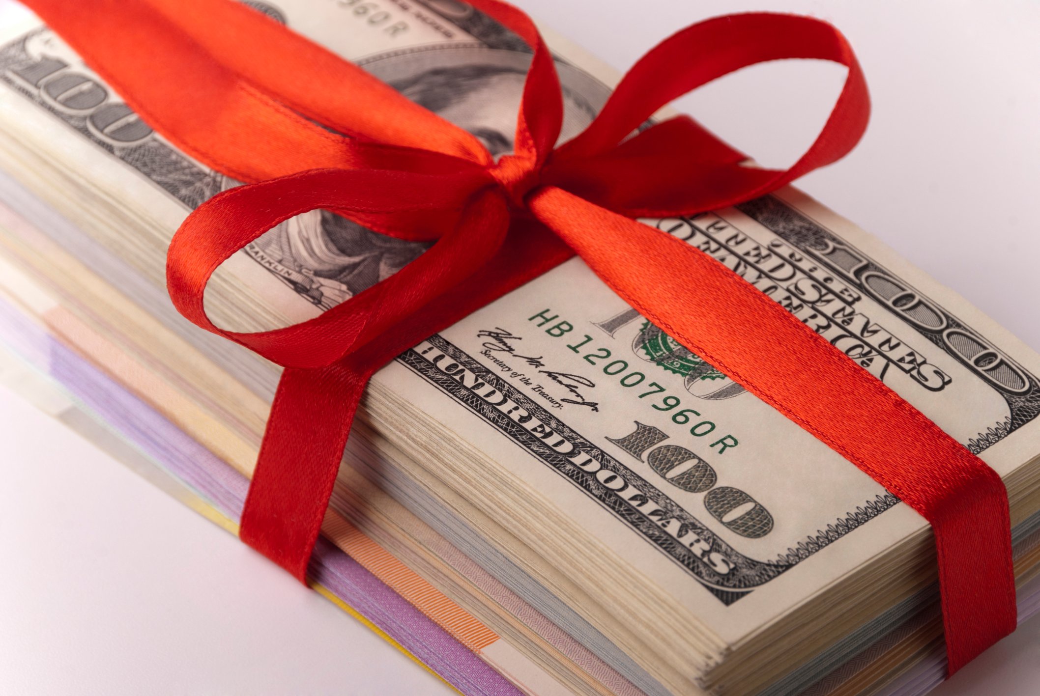Stack of bills wrapped in a red bow