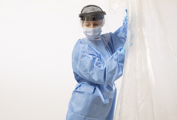 A healthcare worker wearing protective gear including a face shield. 