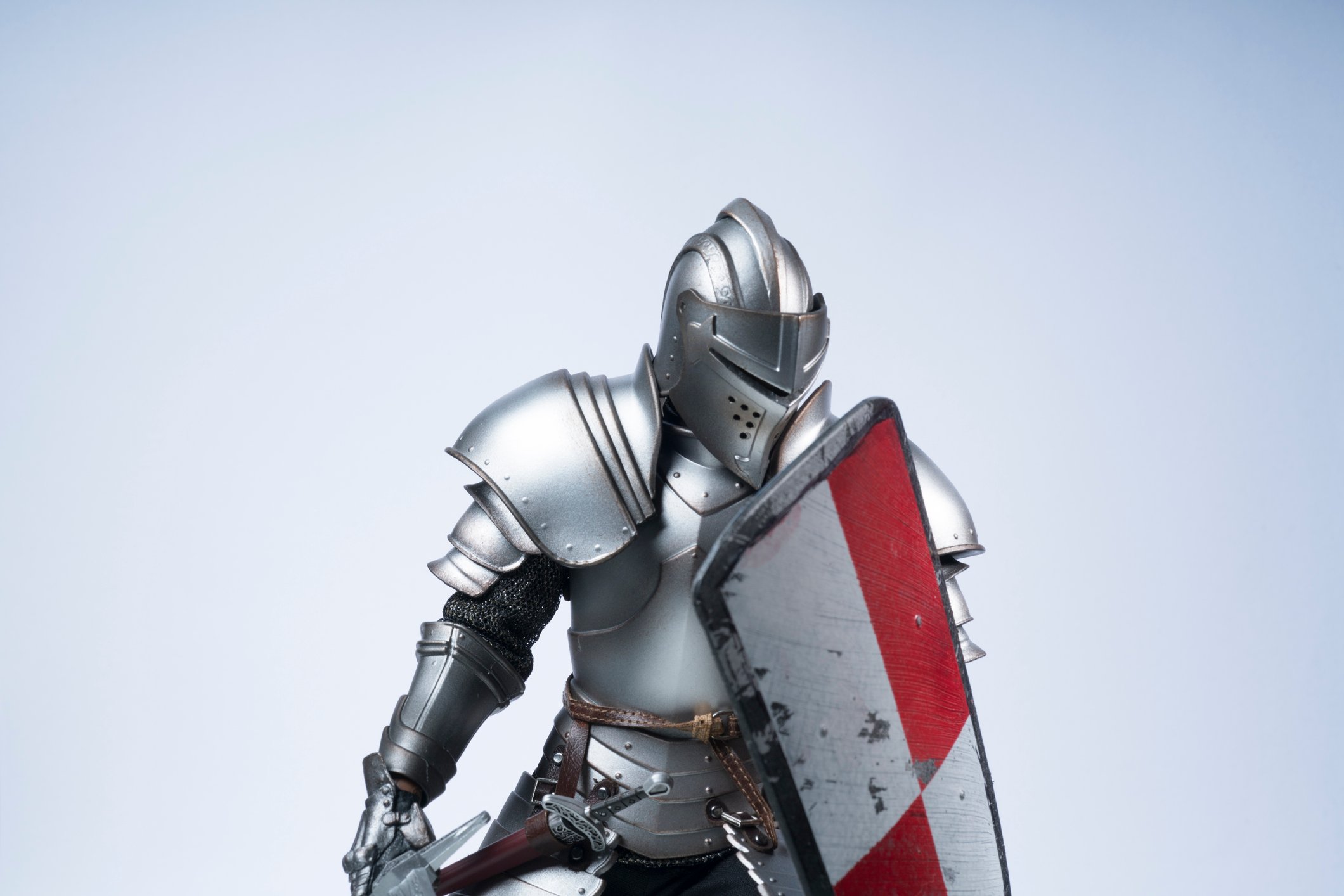 Knight wearing a suit of armor, holding a shield. 
