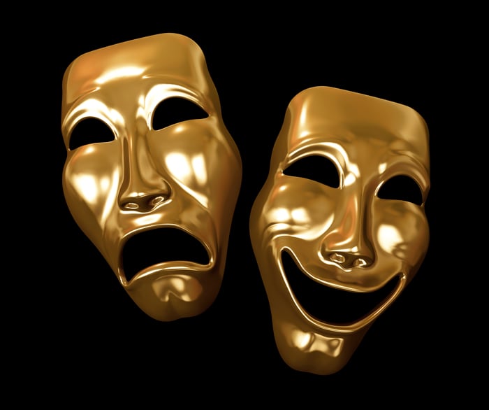 Golden drama and comedy masks on a black background.