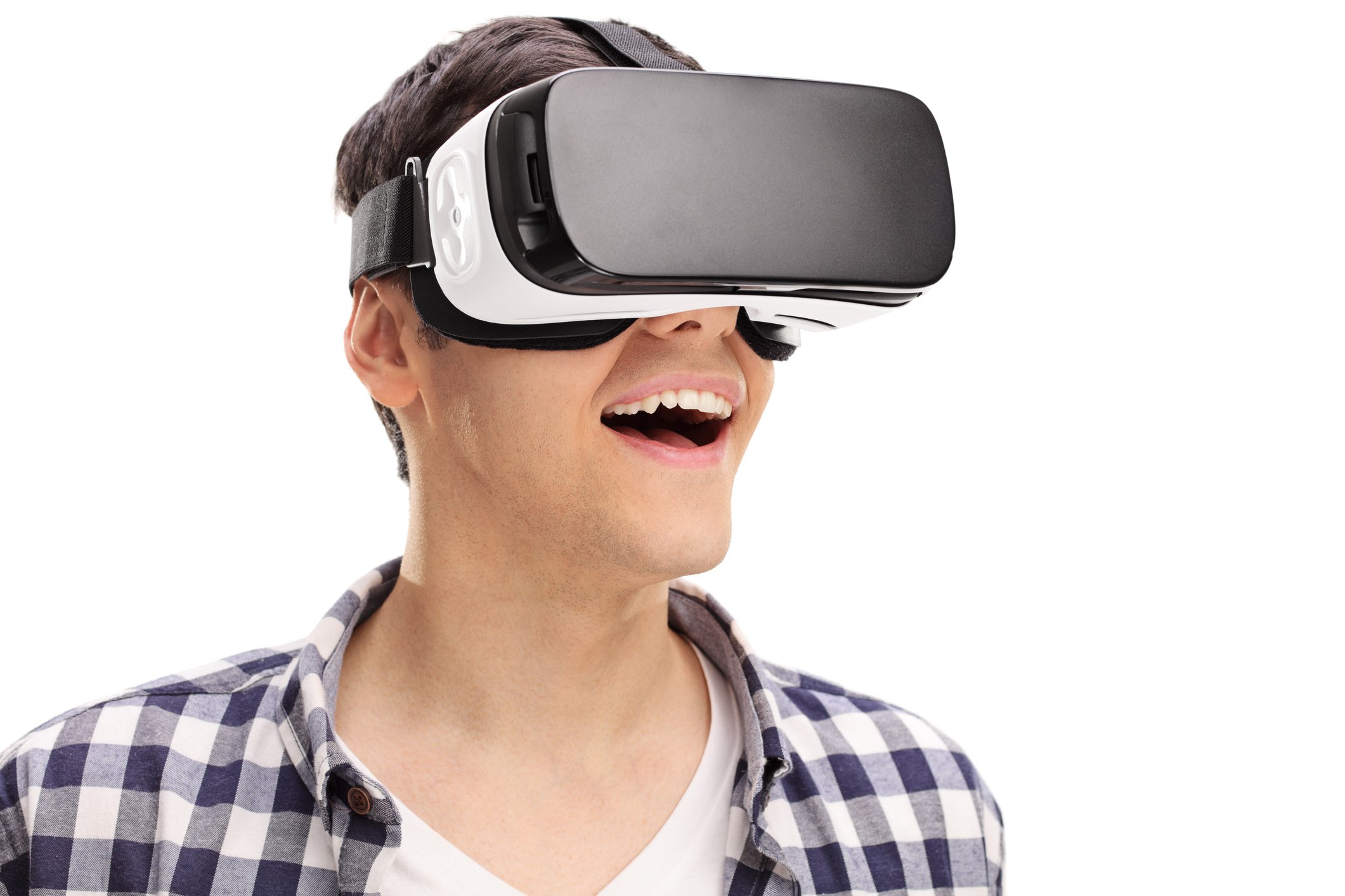 A young man in a checkered shirt looking amazed and wearing a virtual reality headset. 