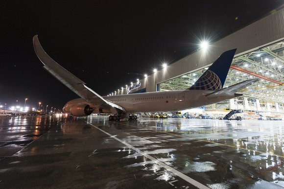 A United Airlines 787 exiting a hanger at night.
