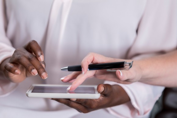 A man signing his name on a tablet. 