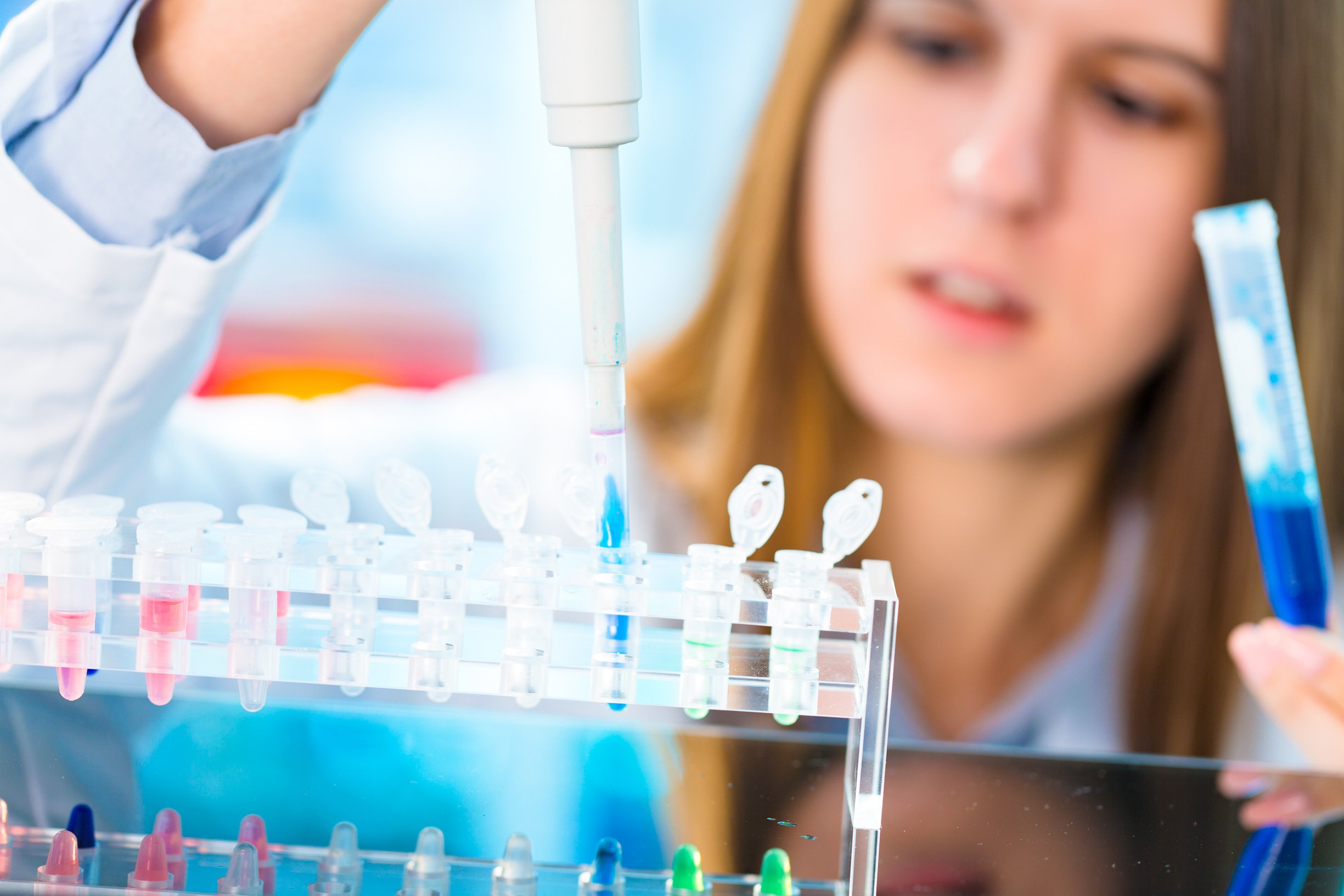 Researcher taking sample from test tubes