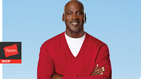 Michael Jordan smiling in a hanes T-shirt and sweater. 