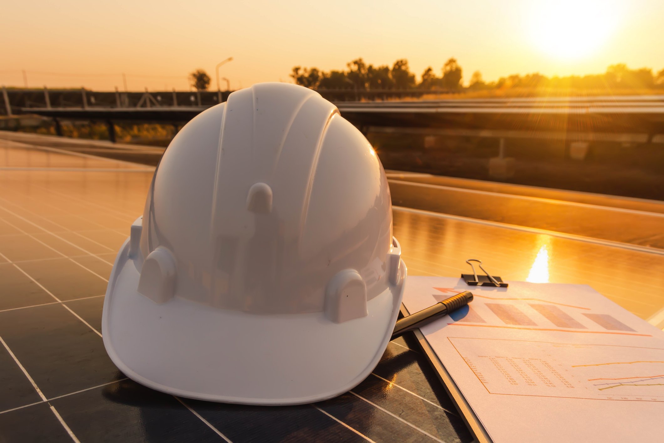Hard hat beside clipboard representing growth projects.