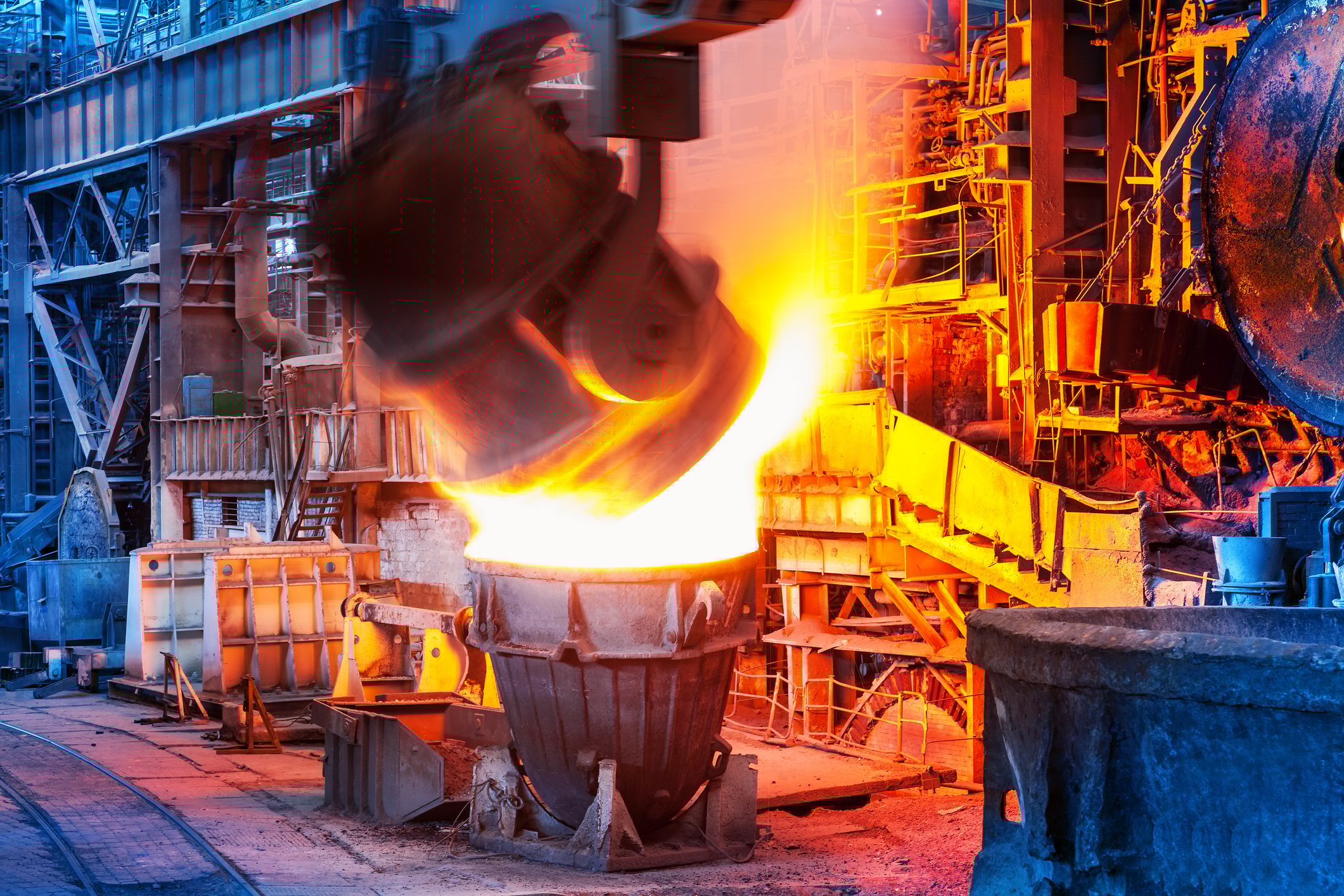 Ladle pouring molten steel during steelmaking process.