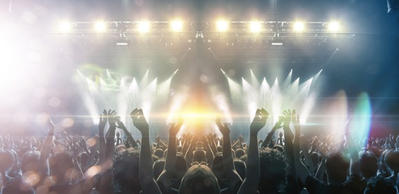live concert crowd cheering in front of lights and stage