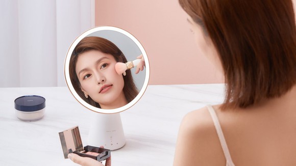 A Chinese woman applies makeup with the help of a Tmall Genie Queen smart mirror.