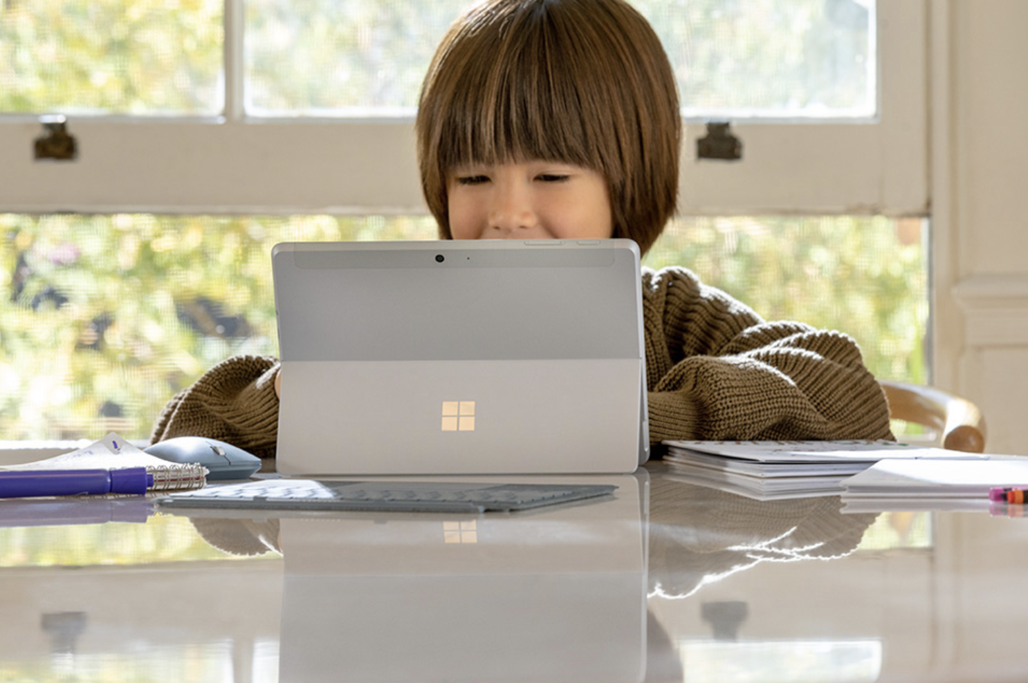 A young boy at home using a Microsoft Surface tablet.
