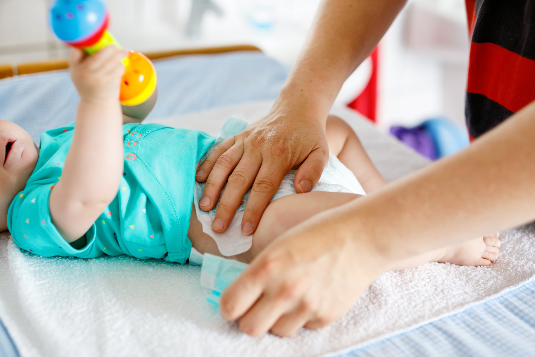 Hands changing a baby's diaper