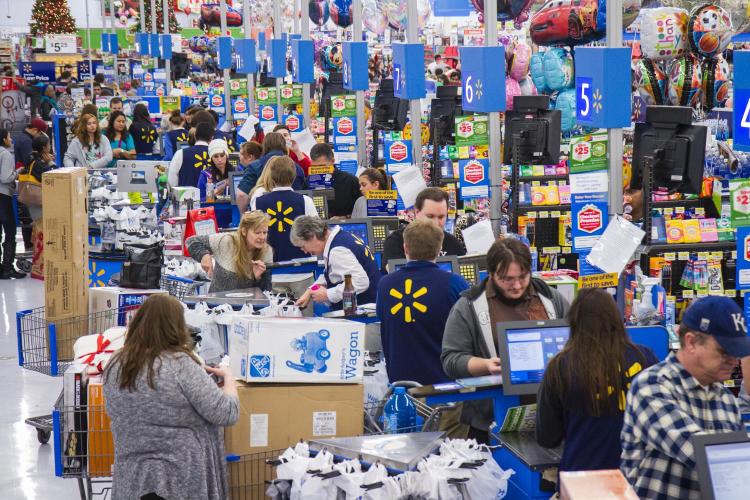 Checkout counters packed with customers inside of a Walmart.