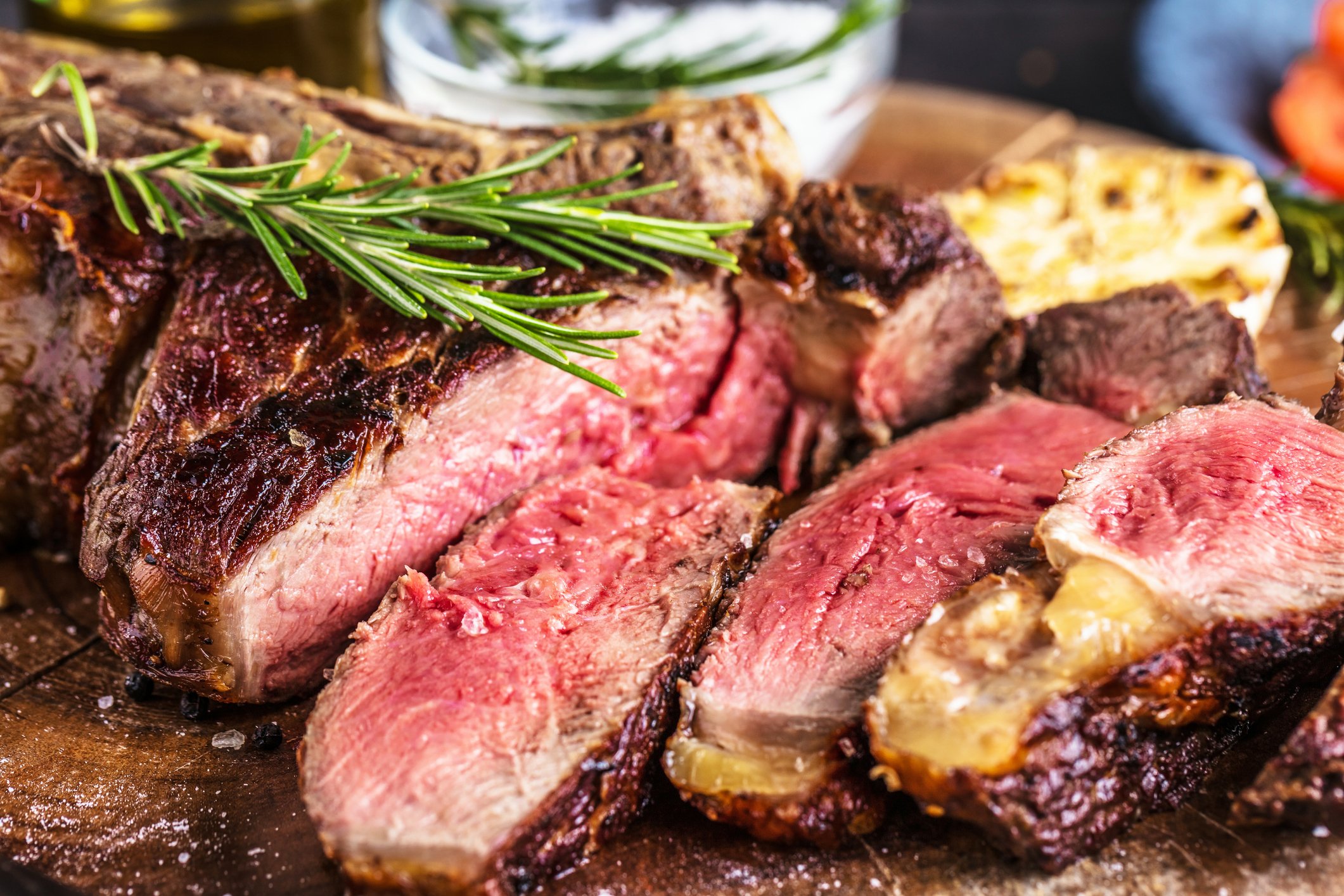 A fresh sliced steak with a sprig of herbs on top