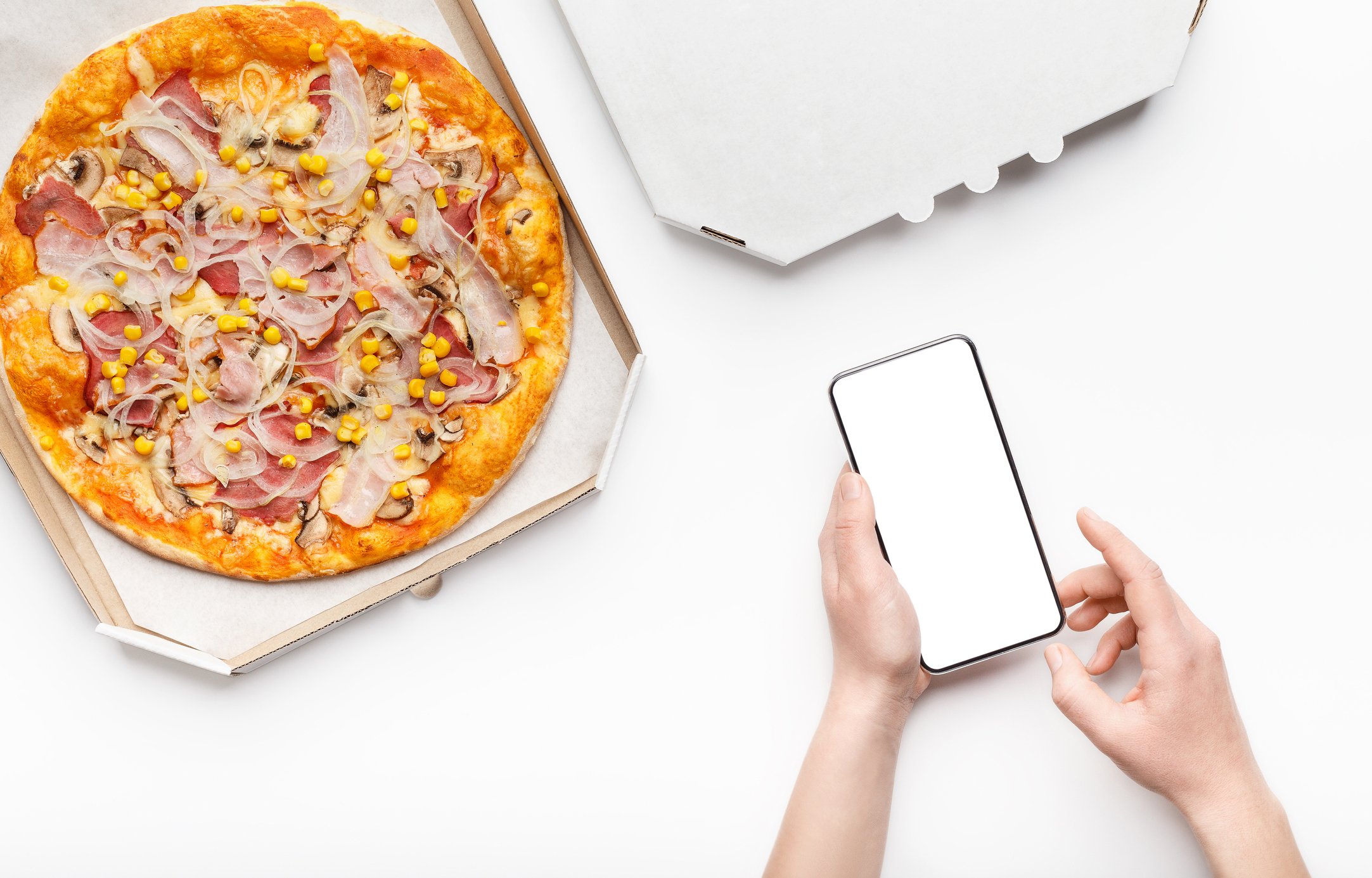 Hands hold a smartphone just above an open box containing a pizza