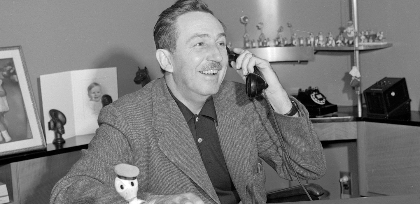 Black and white photo of Walt Disney talking on the phone.
