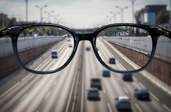 A pair of glasses in front of a highway.