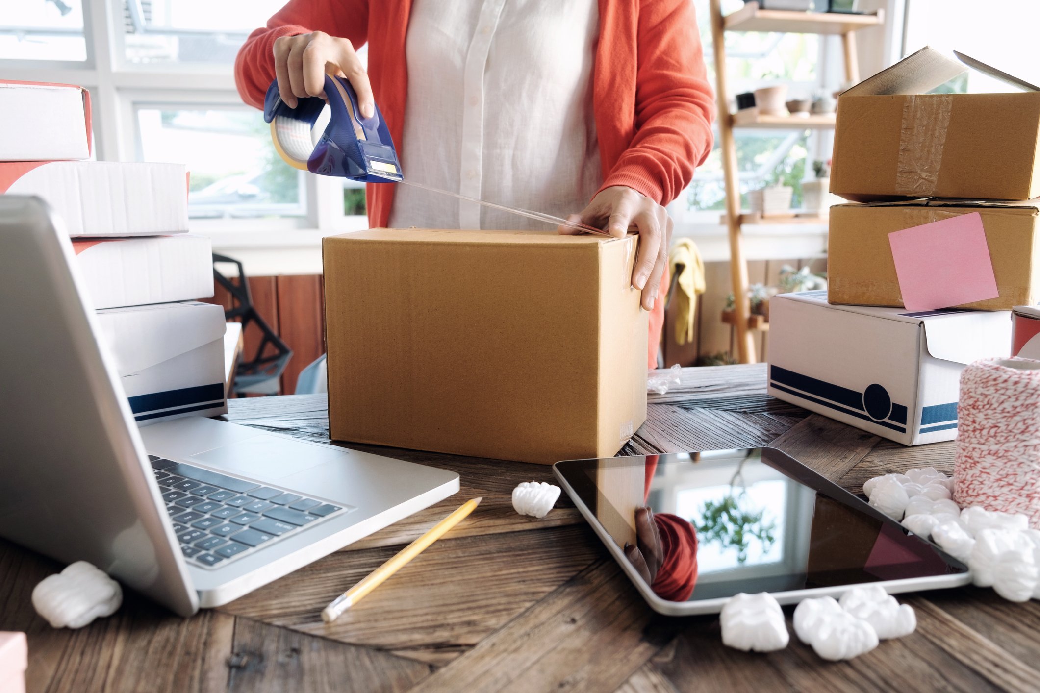 Person in office taping a box for shipment.