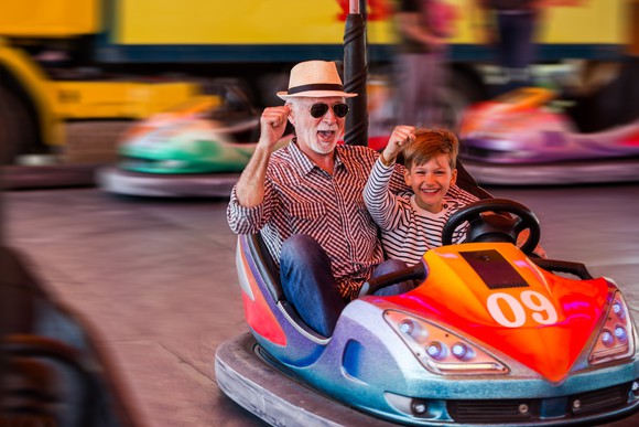 child and grandparent riding bumper cars