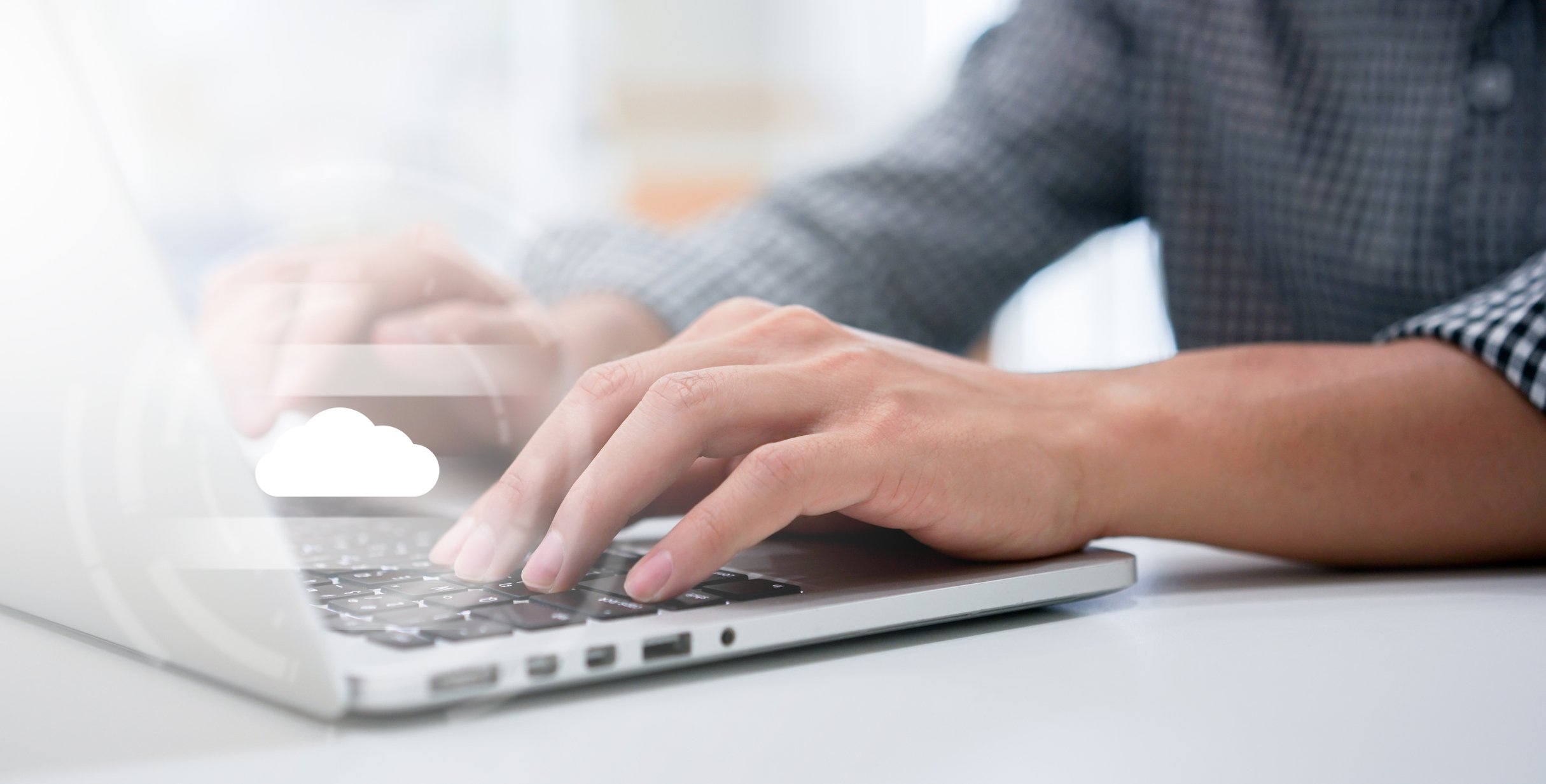 A person's hands are shown on a laptop with a cloud image above them.