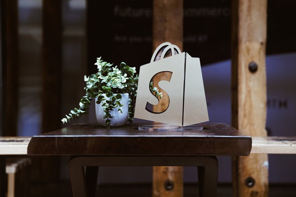 The Shopify logo on a virtual bag sitting on a table.