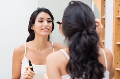 woman putting on eye makeup