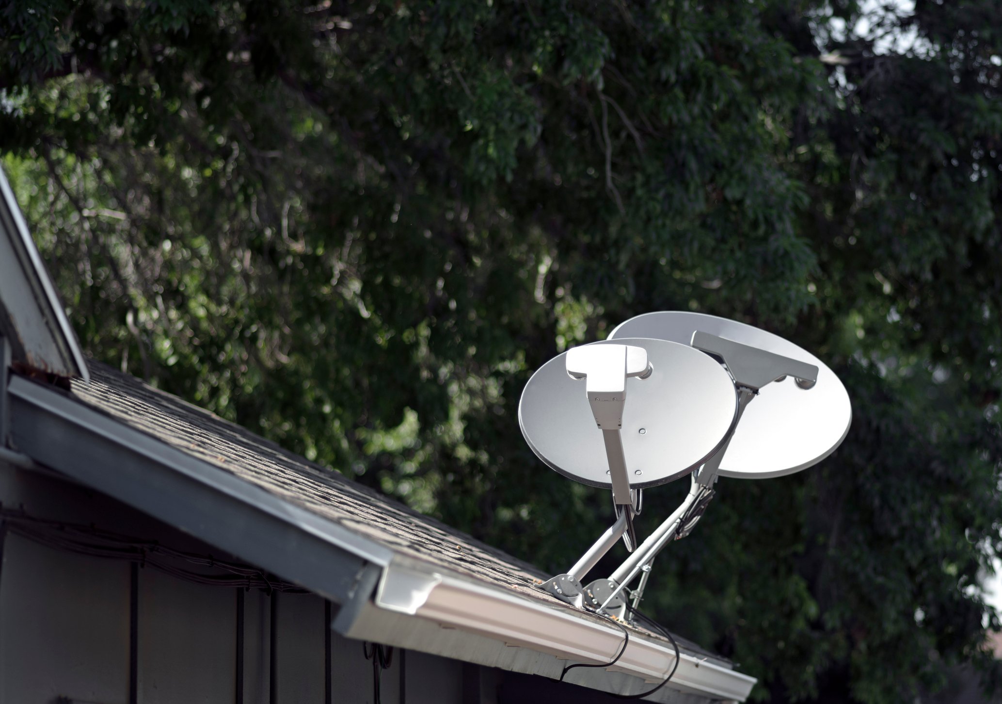 A pair of satellite dishes on a roof.