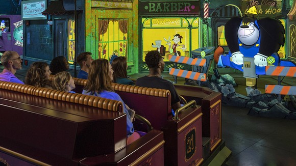 Mickey & Minnie's Runaway Railway riders in a busy street scene.