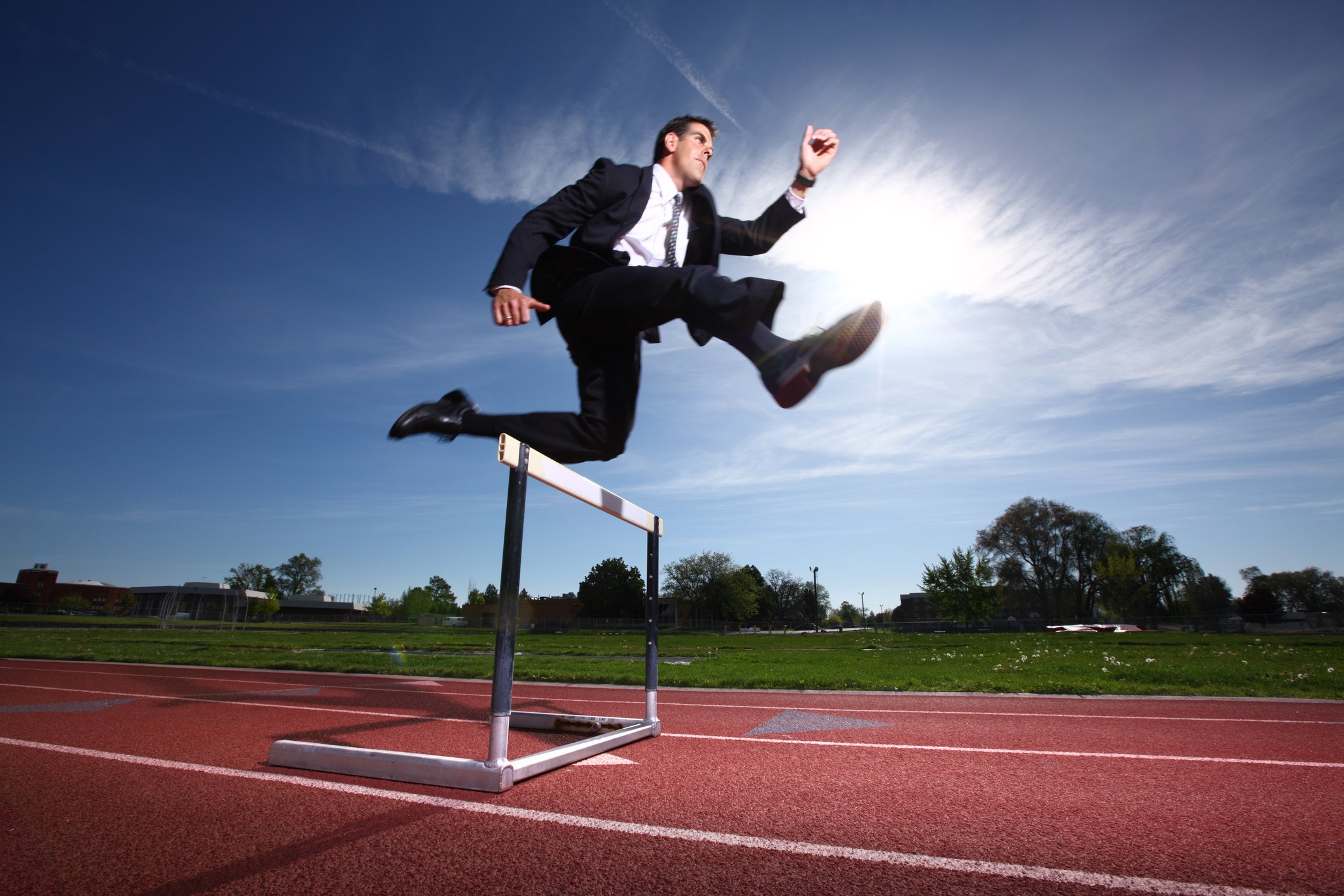 Businessperson leaping over a hurdle