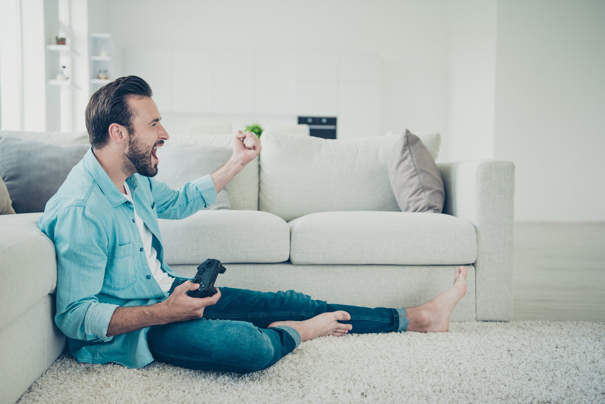 A man sitting on the floor with a video game controller.