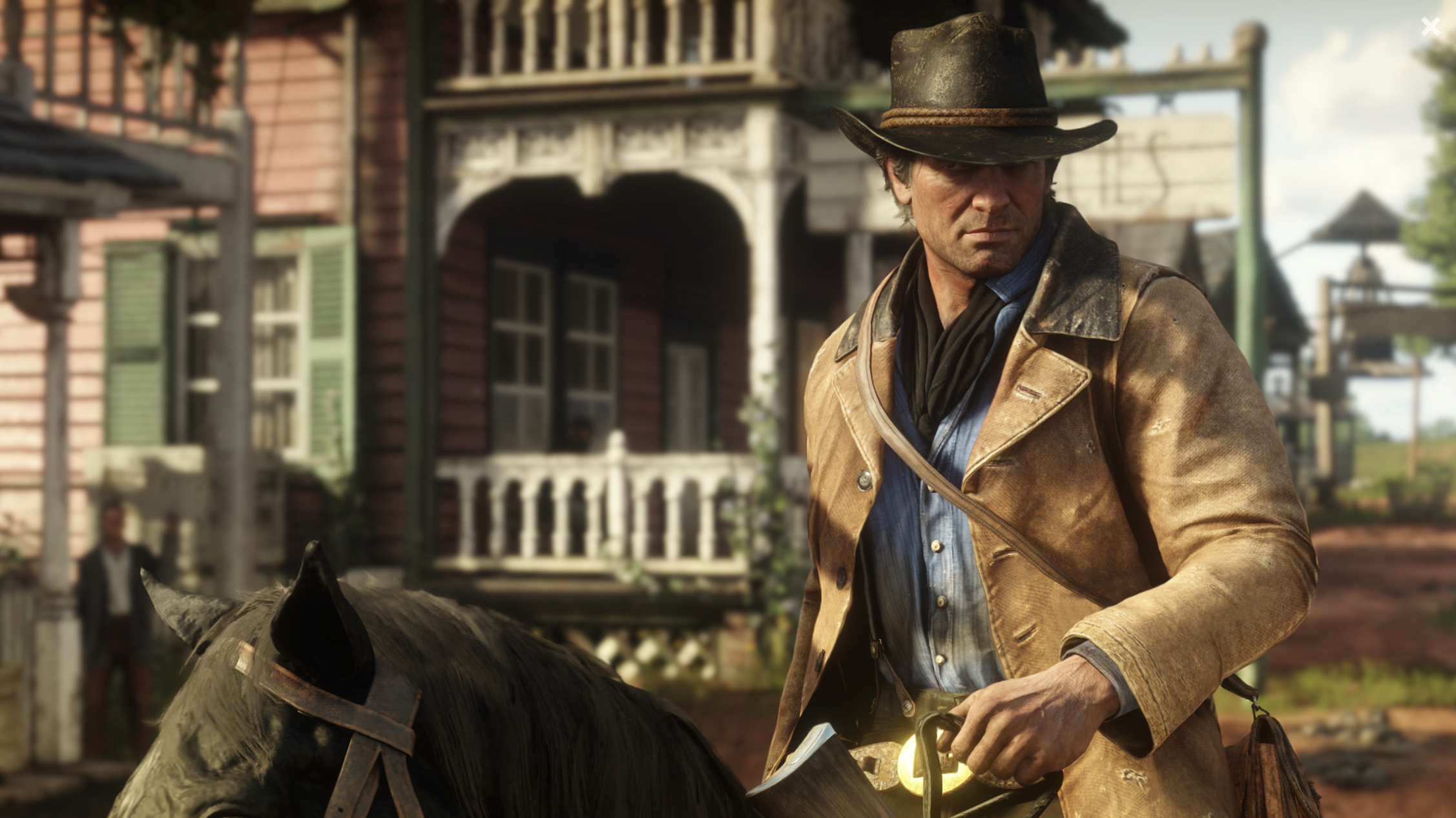 A character from Take-Two's Red Dead Redemption video game riding a horse through an old western town.