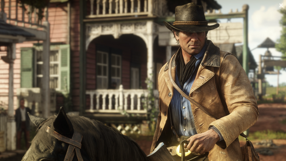 A character from Take-Two's Red Dead Redemption video game riding a horse through an old western town.