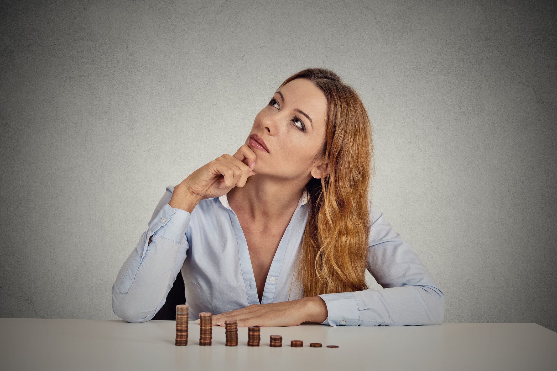 Woman sitting down with stacks of pennies in front of her