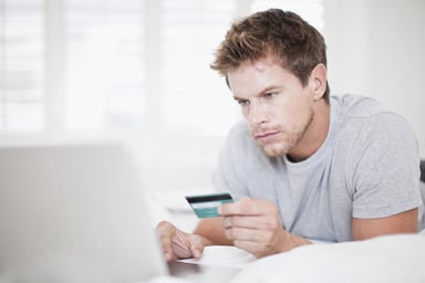 man with credit card shopping on laptop computer